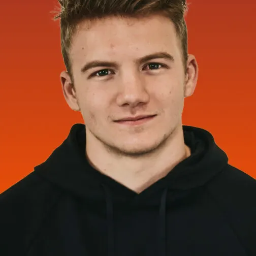 Studio portrait of a smiling colleague in a black hoodie on an orange backdrop