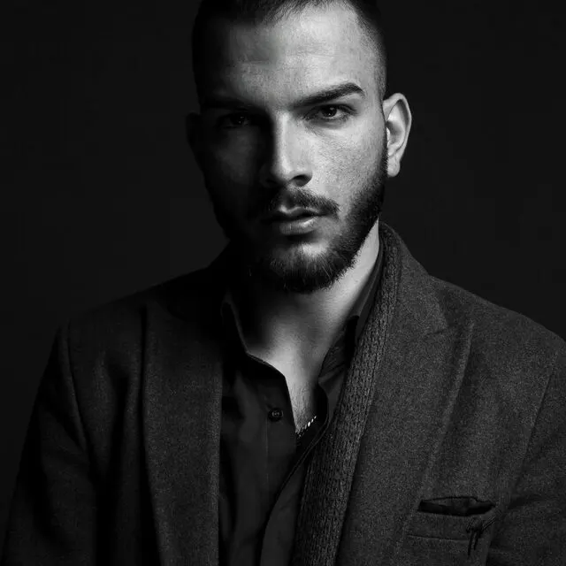 Black and white portrait of a colleague in a jacket and open-collar shirt