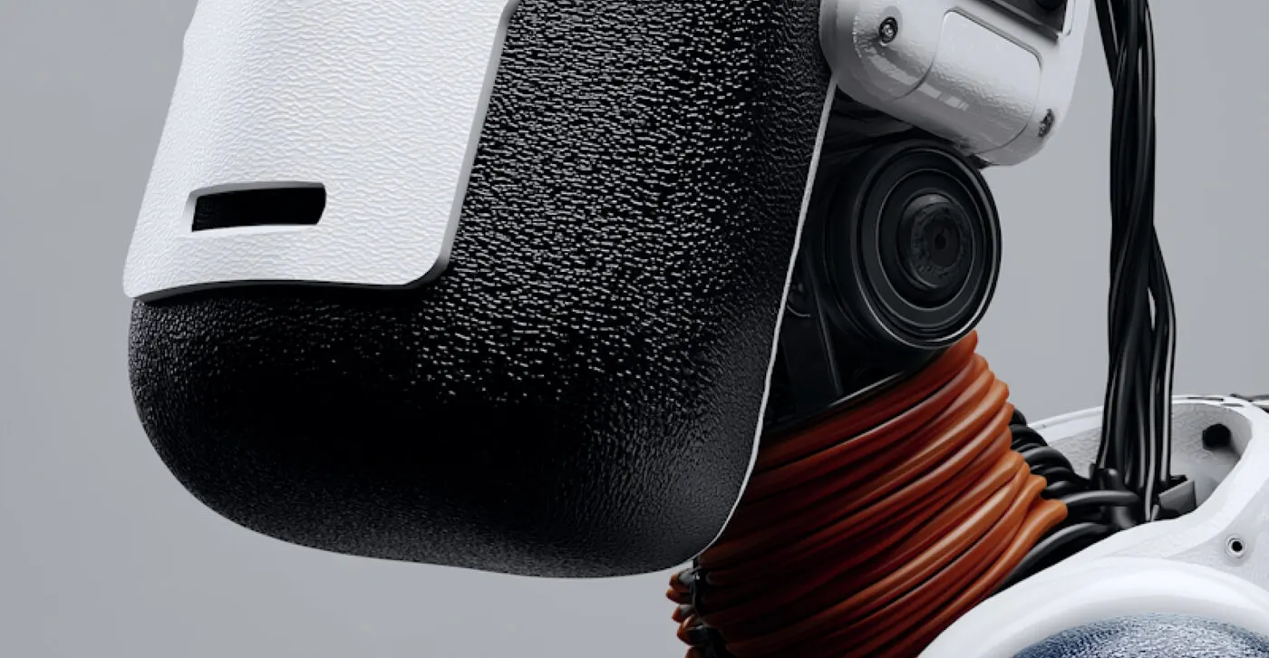 Close-up of a white and black textured robotic head with a lens and orange cabling